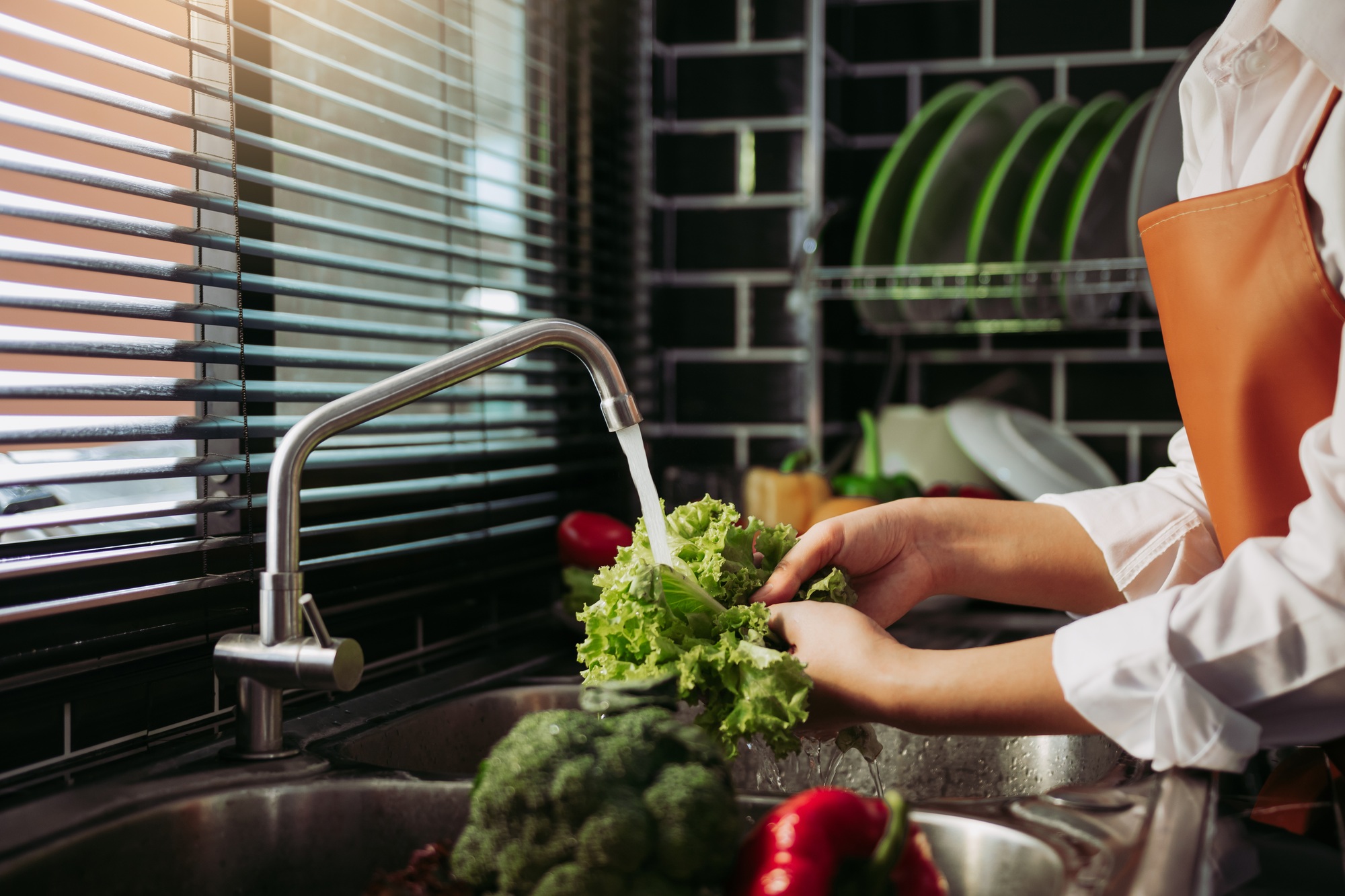 Asian hands woman washing vegetables salad and preparation healthy food in kitchen.